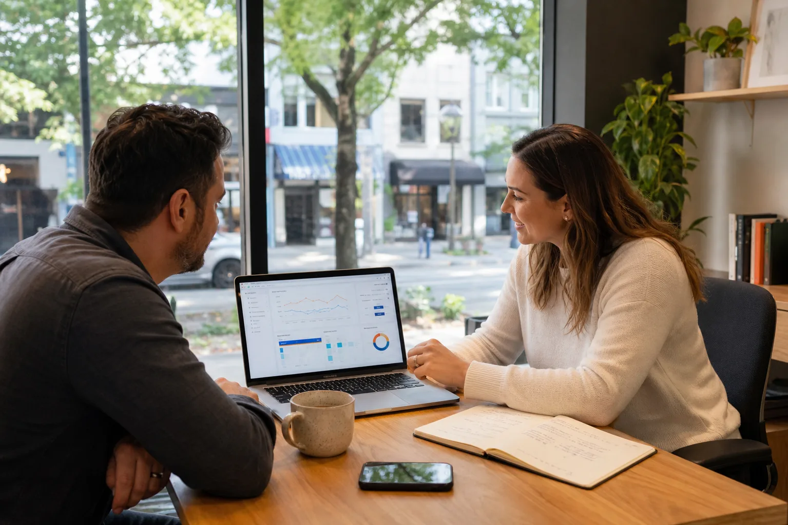 Small business owner and marketing strategist reviewing Google Ads management on a laptop in a modern office